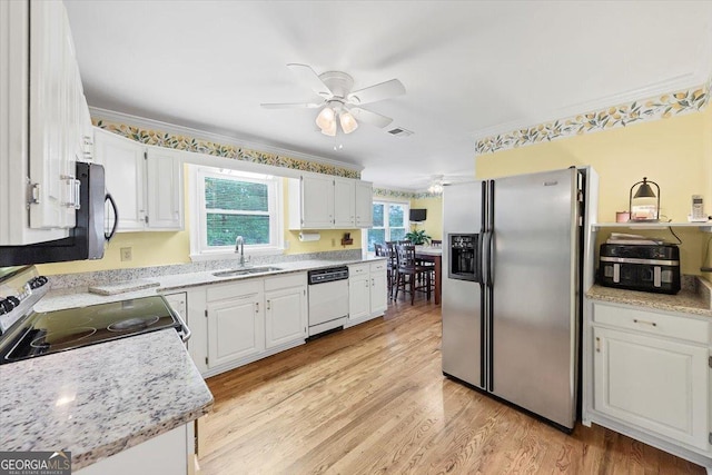 kitchen with visible vents, a ceiling fan, light wood-type flooring, a sink, and stainless steel appliances