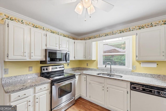 kitchen with a sink, white cabinets, light stone countertops, and stainless steel appliances