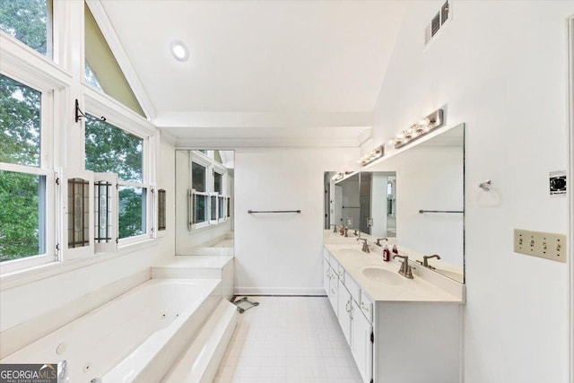 full bath with tile patterned floors, a tub with jets, a sink, and lofted ceiling