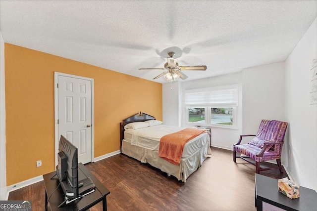 bedroom featuring baseboards, ceiling fan, dark wood-style floors, and a textured ceiling
