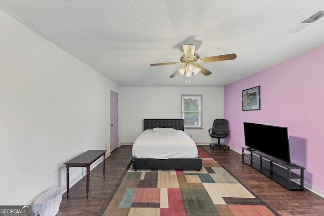 bedroom featuring baseboards, a ceiling fan, wood finished floors, and visible vents