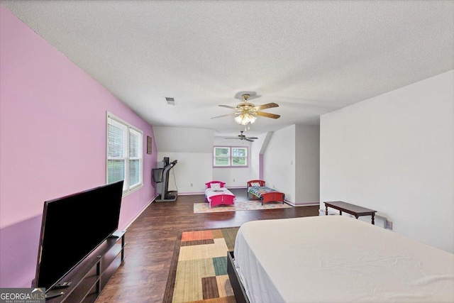 interior space with dark wood-style flooring, a textured ceiling, a ceiling fan, baseboards, and visible vents