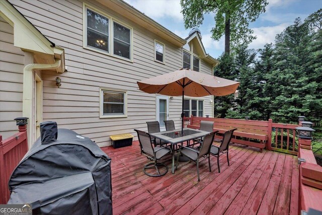 wooden terrace with outdoor dining space and grilling area
