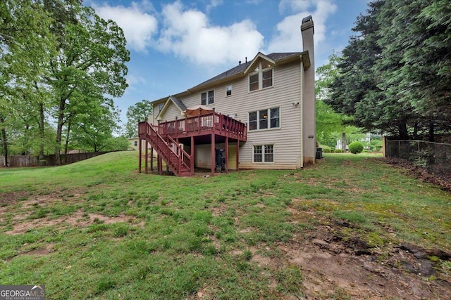 rear view of house featuring a chimney, a lawn, a deck, stairway, and fence