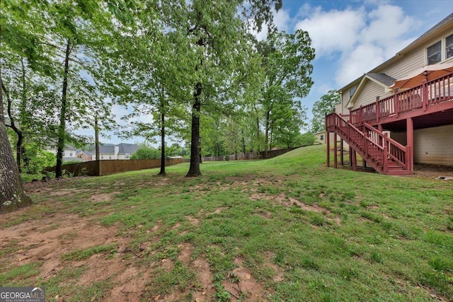 view of yard with stairway, a deck, and fence