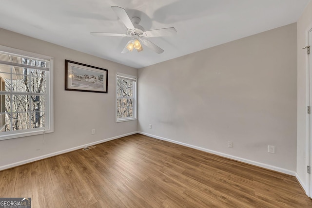 unfurnished room featuring baseboards, ceiling fan, and wood finished floors