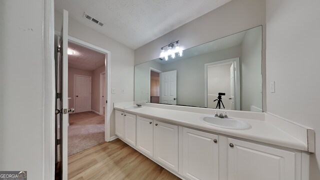 8256 Milam Loop, Fairburn, GA 30213 - full bathroom with double vanity, visible vents, a sink, and wood finished floors