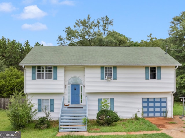 raised ranch featuring a garage and driveway