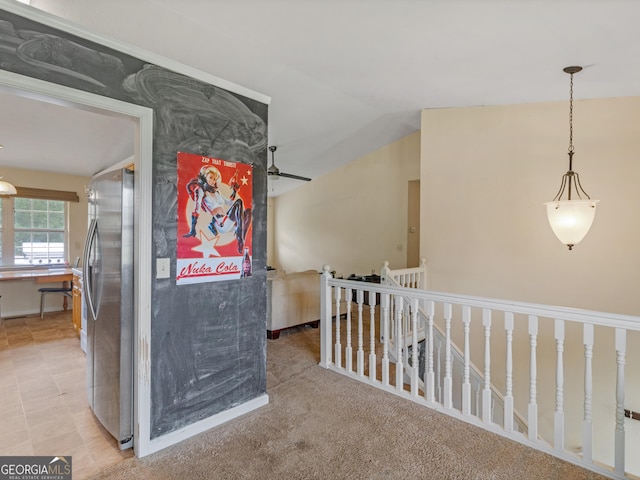 hall with lofted ceiling and an upstairs landing