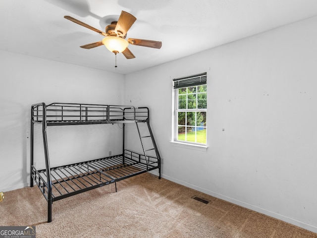 bedroom featuring baseboards, visible vents, ceiling fan, and carpet