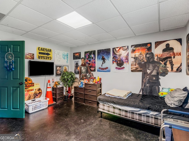 bedroom featuring finished concrete floors and a paneled ceiling