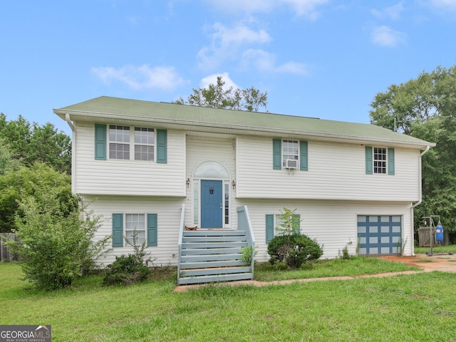 bi-level home featuring an attached garage, driveway, and a front yard
