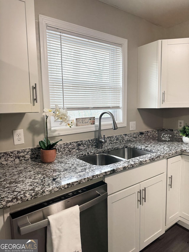 kitchen featuring a sink, light stone countertops, white cabinetry, and dishwasher