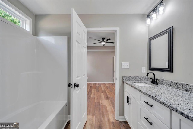 327 Peach Cir, Fort Valley, GA 31030 - full bath featuring vanity, wood finished floors, a ceiling fan, and tub / shower combination