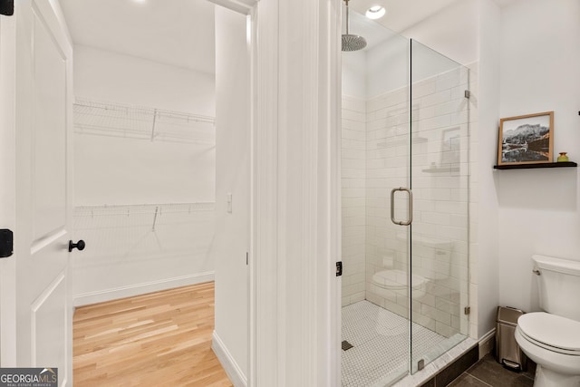 686 Exchange St SE, Atlanta, GA 30315 - full bathroom with a walk in closet, a stall shower, toilet, and wood finished floors