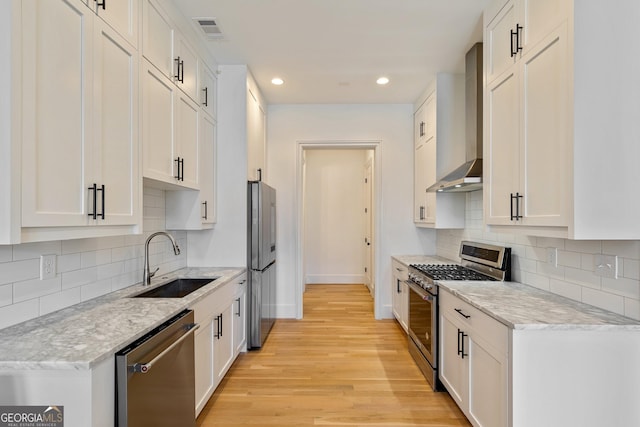 686 Exchange St SE, Atlanta, GA 30315 - kitchen with visible vents, baseboards, wall chimney range hood, a sink, and appliances with stainless steel finishes