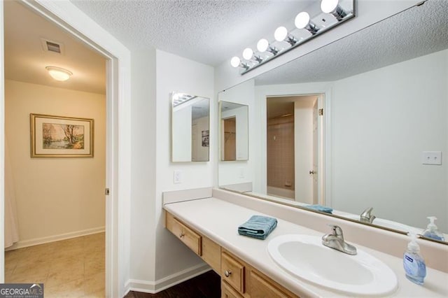 199 14th St Unit 409, Atlanta, GA 30309 - bathroom with vanity, baseboards, a textured ceiling, and visible vents