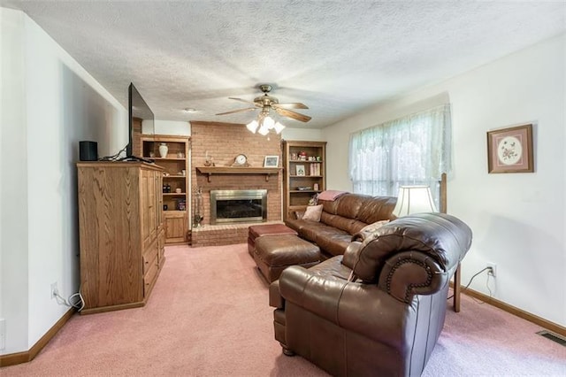 living area with visible vents, a fireplace, light carpet, baseboards, and a ceiling fan