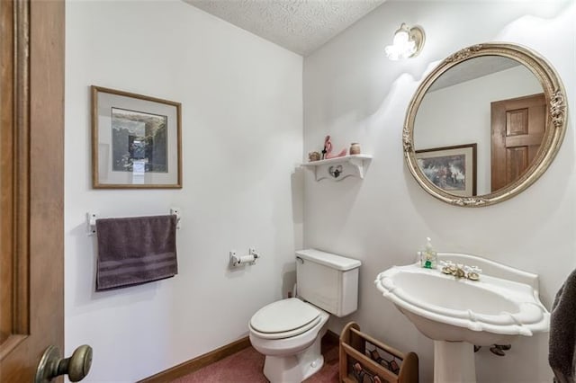 half bathroom featuring toilet and a textured ceiling