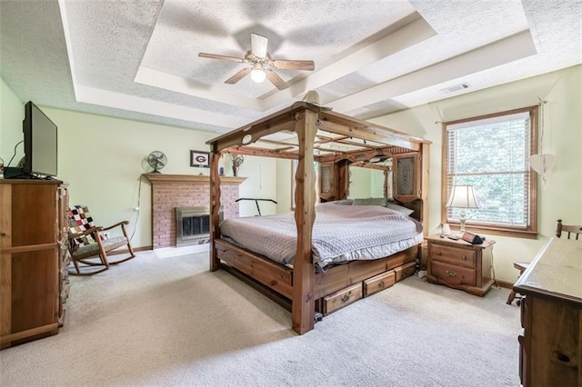 bedroom featuring a textured ceiling, visible vents, baseboards, light carpet, and a tray ceiling