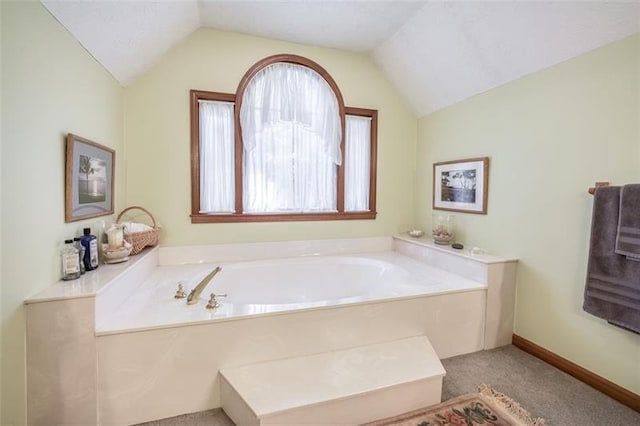 full bath featuring a garden tub and vaulted ceiling