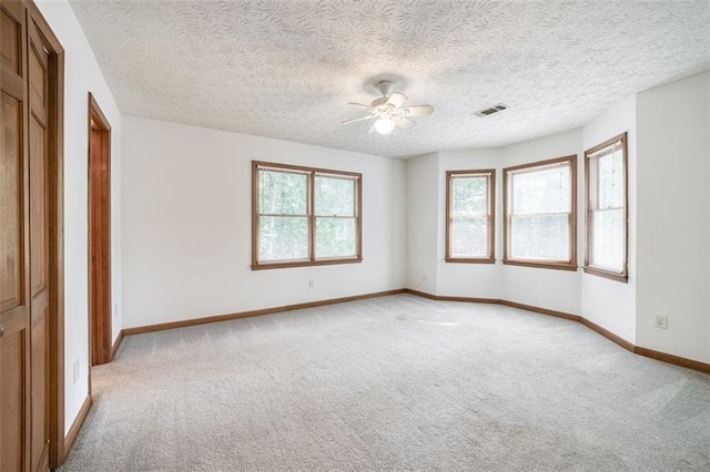 unfurnished bedroom featuring baseboards, visible vents, light carpet, and ceiling fan