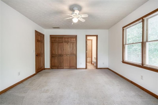 unfurnished bedroom with baseboards, a closet, and light colored carpet