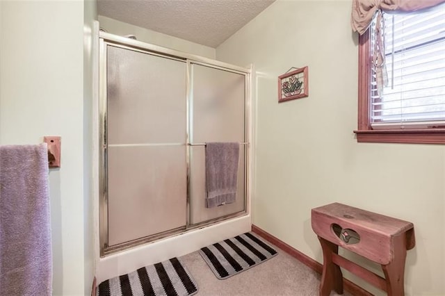 bathroom with a textured ceiling and a stall shower