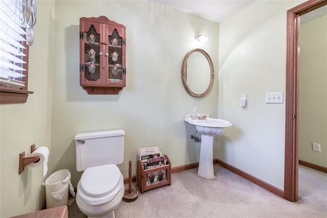 half bath with baseboards and toilet