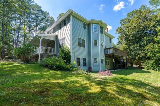 back of property featuring a lawn and a wooden deck