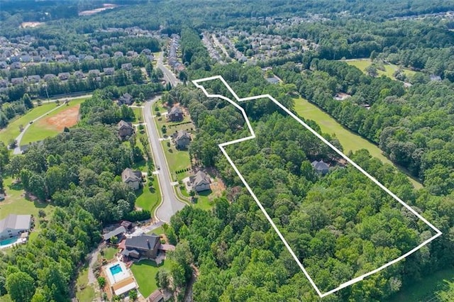bird's eye view with a wooded view