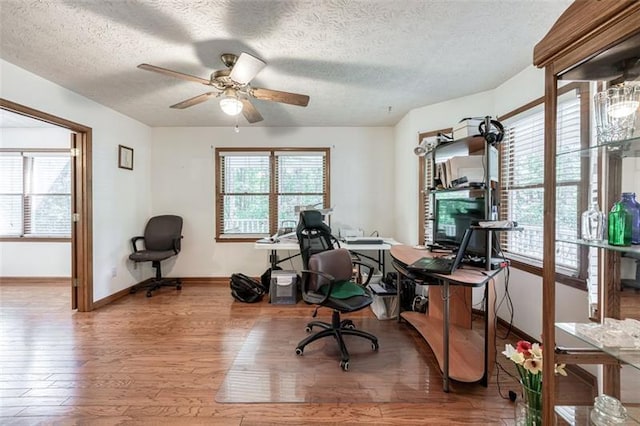 home office with baseboards, a ceiling fan, a textured ceiling, and wood finished floors