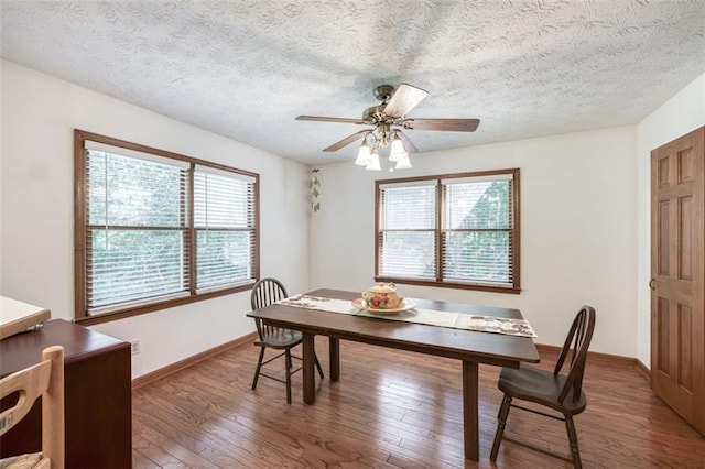 dining area featuring baseboards, a textured ceiling, ceiling fan, and wood finished floors