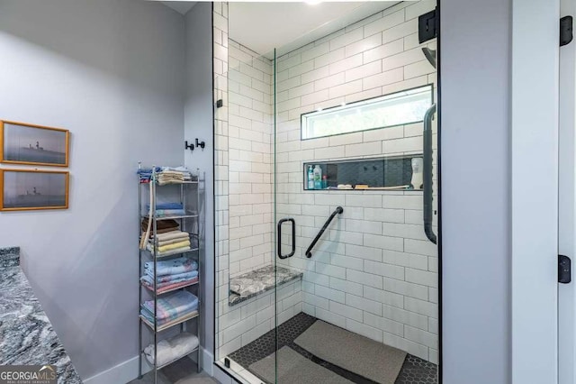bathroom featuring baseboards and a shower stall