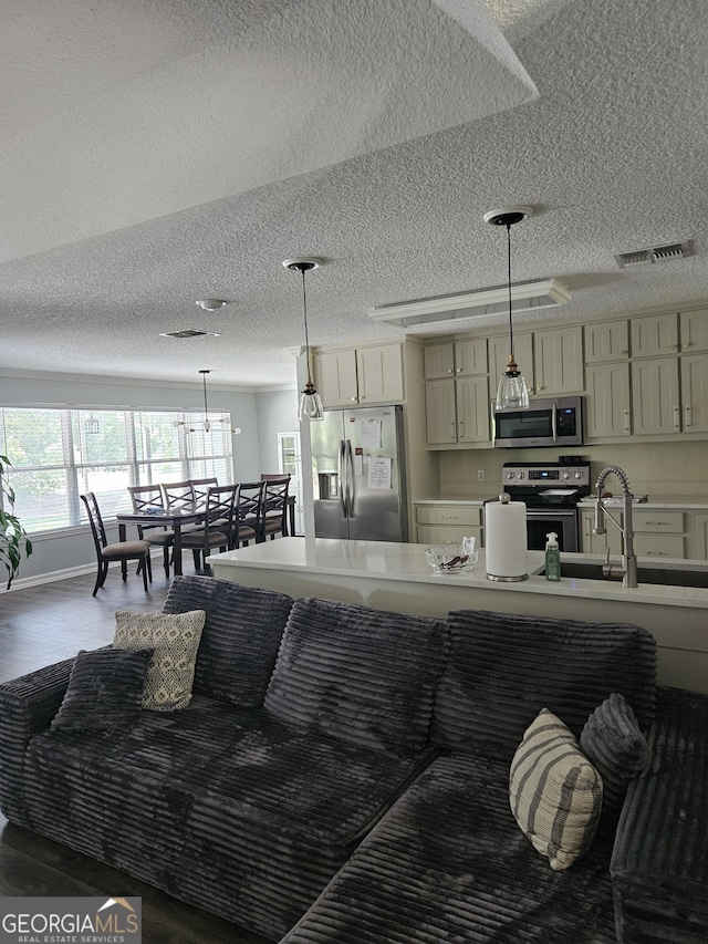 kitchen with visible vents, a textured ceiling, wood finished floors, and stainless steel appliances