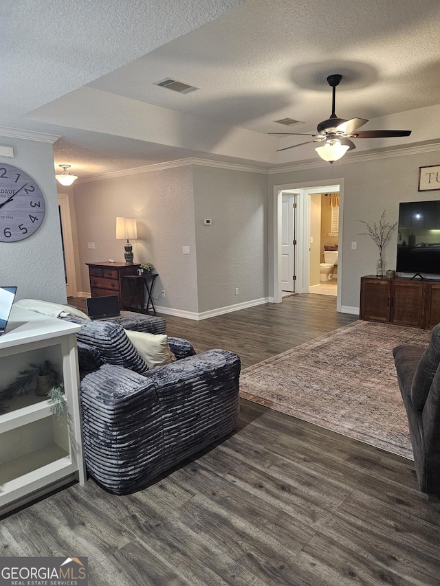 living area featuring visible vents, a textured ceiling, crown molding, and wood finished floors