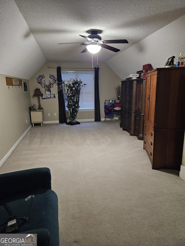 bonus room with a ceiling fan, a textured ceiling, lofted ceiling, and light carpet