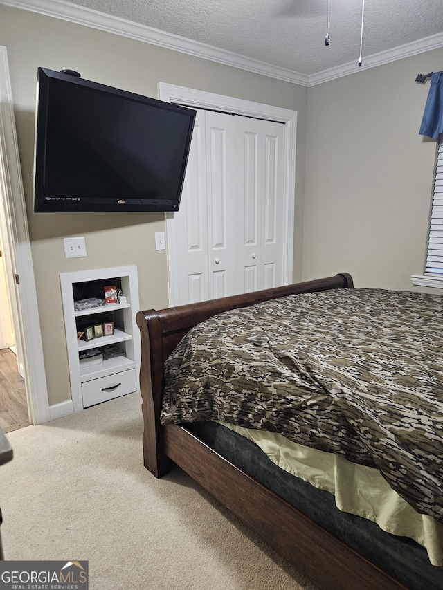 bedroom featuring a closet, ornamental molding, and carpet flooring