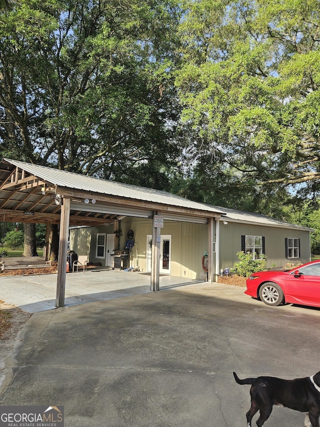 view of front of property with metal roof, driveway, and a carport