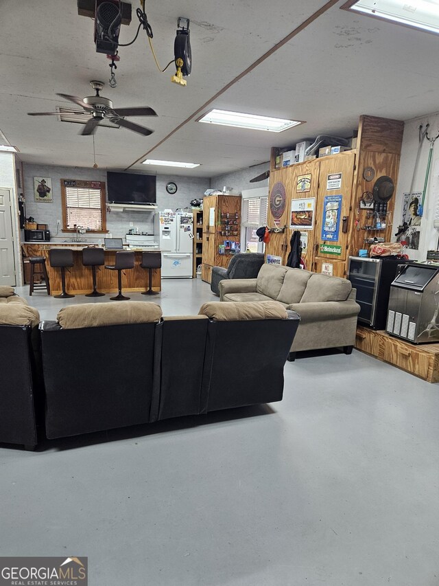 living room featuring ceiling fan and concrete floors