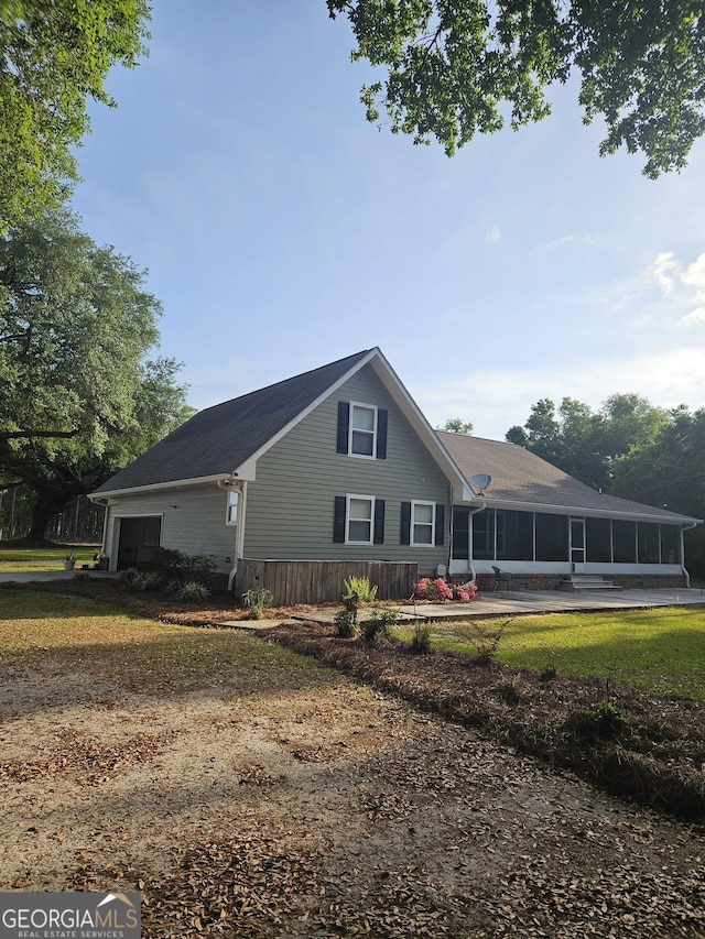 back of property featuring a sunroom and a garage