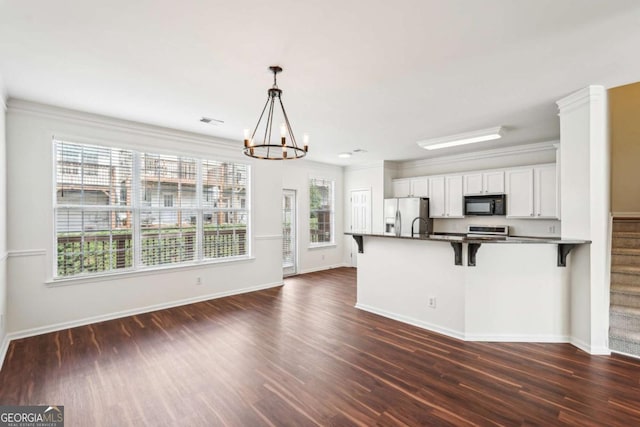3505 Chattahoochee Summit Ln SE Unit 25, Atlanta, GA 30339 - kitchen with black microwave, stainless steel fridge with ice dispenser, a chandelier, a breakfast bar, and white cabinets