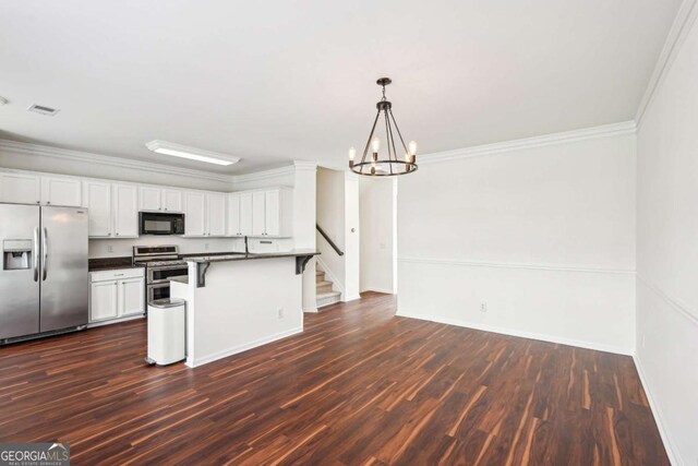 3505 Chattahoochee Summit Ln SE Unit 25, Atlanta, GA 30339 - kitchen featuring appliances with stainless steel finishes, dark countertops, a breakfast bar area, dark wood-type flooring, and white cabinetry