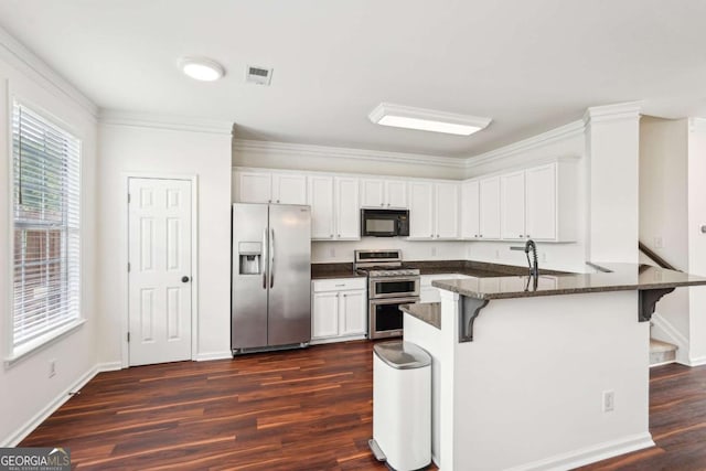 3505 Chattahoochee Summit Ln SE Unit 25, Atlanta, GA 30339 - kitchen featuring stainless steel appliances, a peninsula, dark wood-style flooring, a breakfast bar area, and white cabinetry