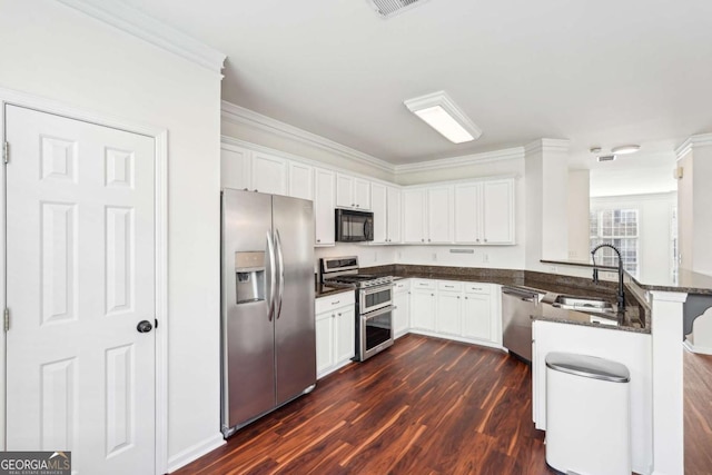 3505 Chattahoochee Summit Ln SE Unit 25, Atlanta, GA 30339 - kitchen with stainless steel appliances, a peninsula, dark wood finished floors, white cabinetry, and crown molding
