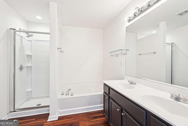 3505 Chattahoochee Summit Ln SE Unit 25, Atlanta, GA 30339 - bathroom featuring wood finished floors, a garden tub, a stall shower, double vanity, and recessed lighting