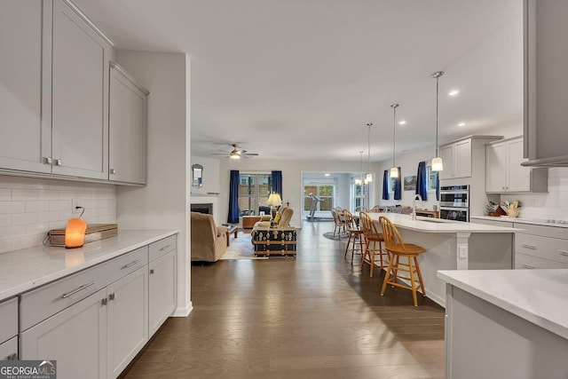 463 Marston Pass, Acworth, GA 30102 - kitchen with decorative backsplash, ceiling fan, dark wood-style floors, and open floor plan