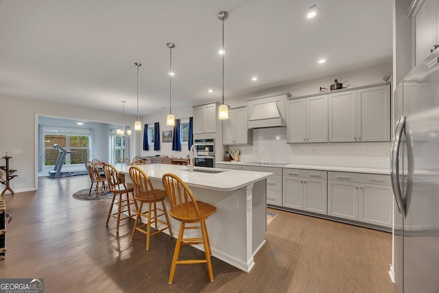 463 Marston Pass, Acworth, GA 30102 - kitchen with a breakfast bar area, tasteful backsplash, a center island with sink, custom exhaust hood, and stainless steel appliances