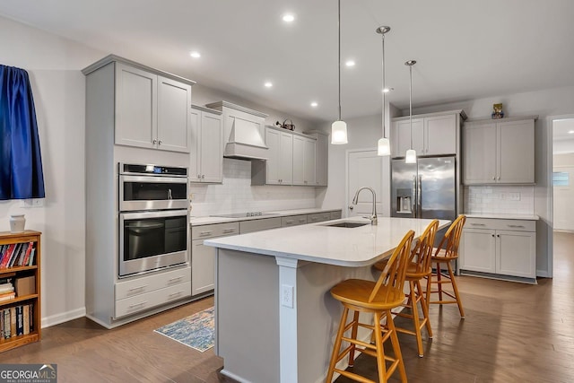 463 Marston Pass, Acworth, GA 30102 - kitchen featuring a kitchen bar, a sink, dark wood finished floors, backsplash, and stainless steel appliances