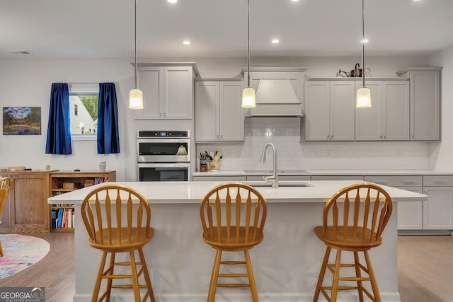 463 Marston Pass, Acworth, GA 30102 - kitchen featuring visible vents, wood finished floors, double oven, custom range hood, and backsplash